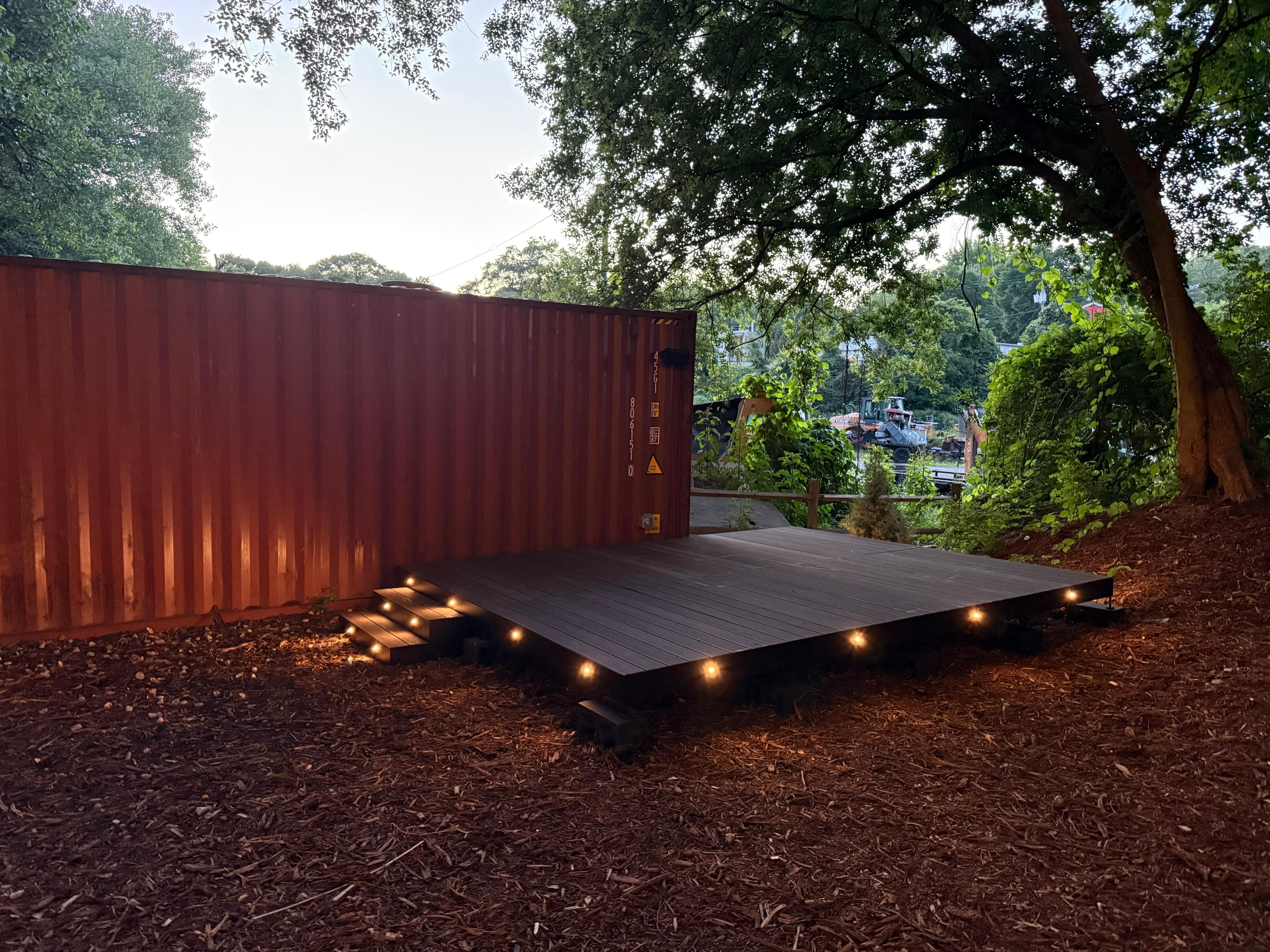 Aluminum deck with composite decking raised and installed at a shipping container